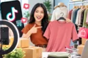 Seorang penjual mempromosikan kaus melalui siaran langsung dengan bantuan kamera dan ring light. (Foto: pegadaian/Ai)